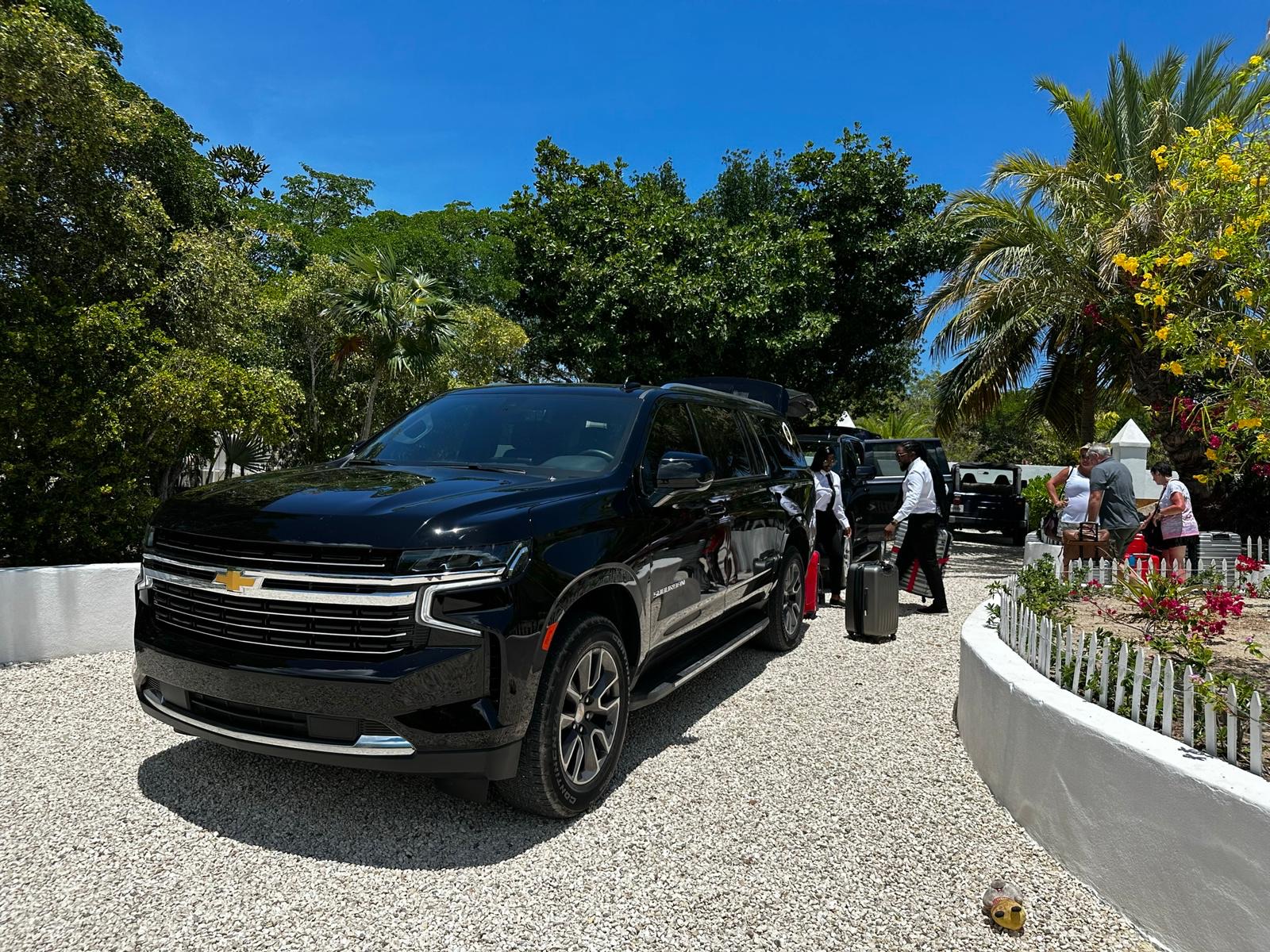 Private SUV and driver loading luggage on the villa driveway