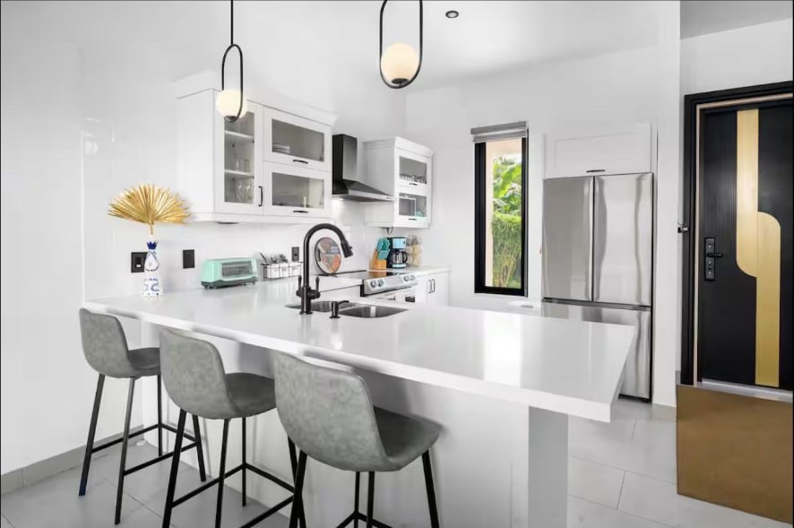 White kitchen with waterfall island and bar stools